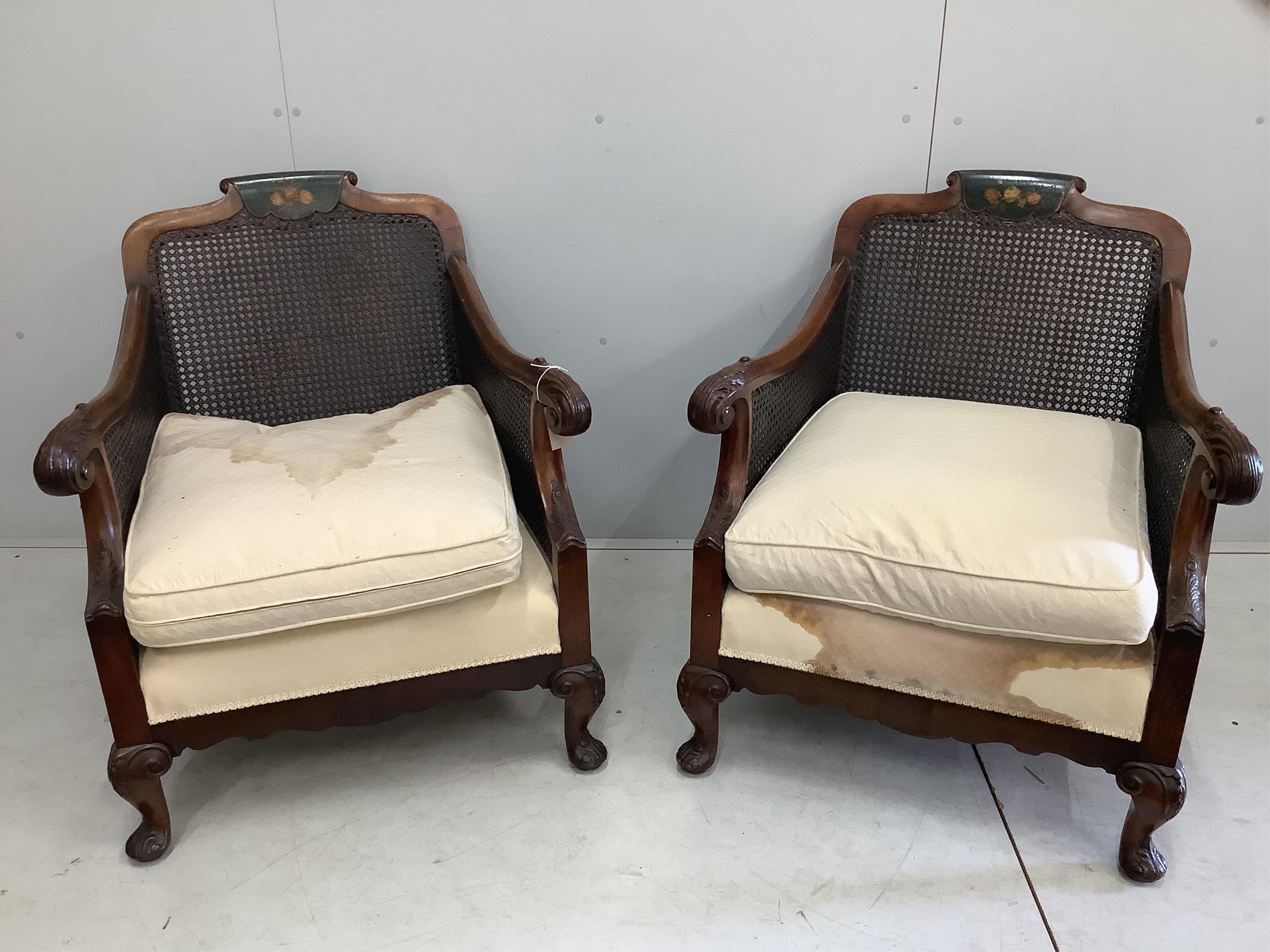 An early 20th century part painted walnut three piece bergere suite, settee width 186cm, depth 78cm, height 80cm. Condition - fair, although one cane panel is damaged and needs repair